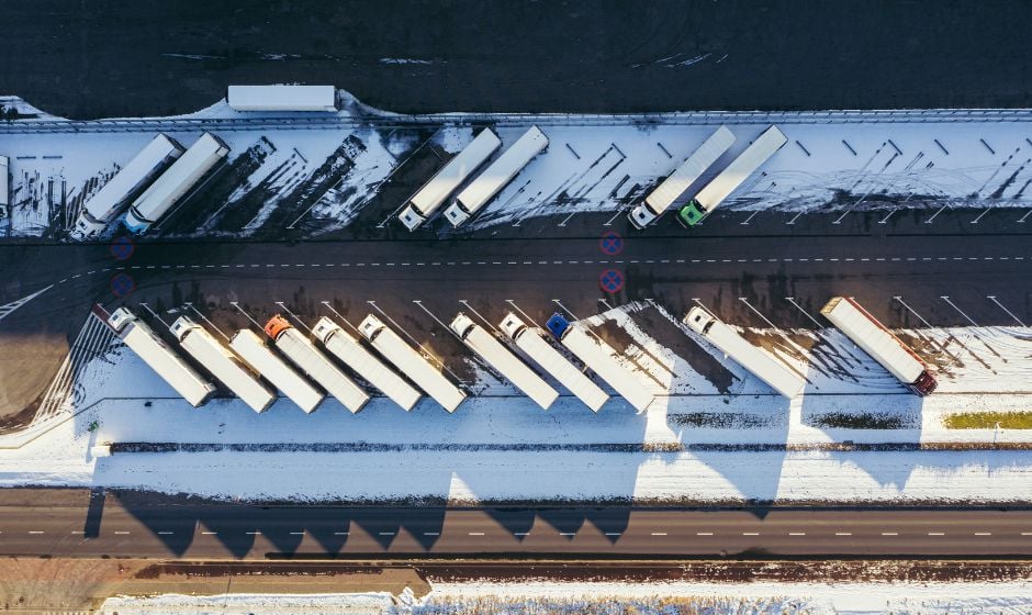 Semi trucks parked at a truck stop in snowy winter