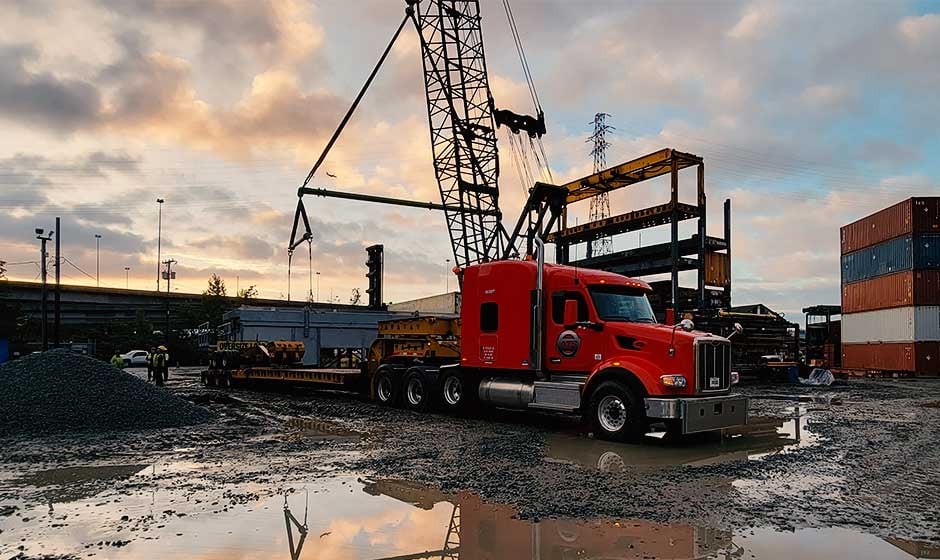 Heavy haul truck construction site loading by crane