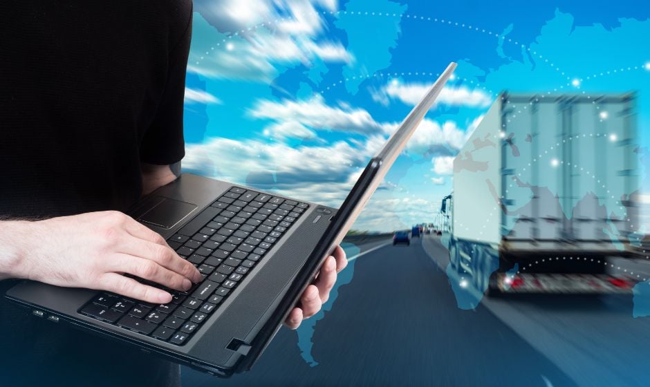 A man uses a laptop to track a freight shipment