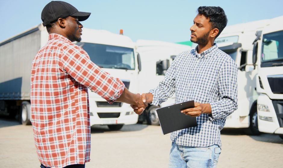 A shipper and broker shake hands on an agreement