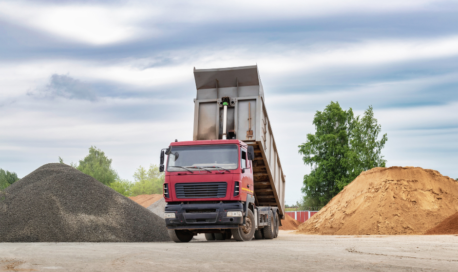 A truck tips its trailer to unload bulk materials