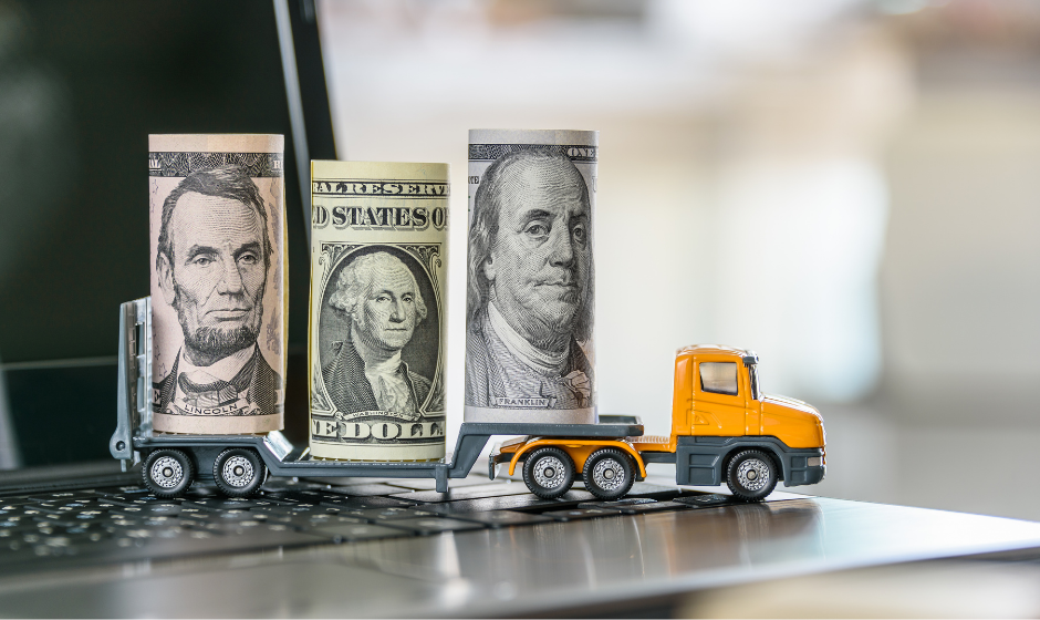A toy flatbed carries several rolls of U.S. currency
