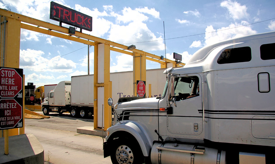 A semi truck waits at a border crossing