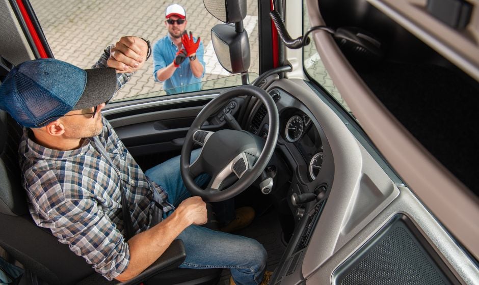 Trucker behind wheel talks to receiver through open window