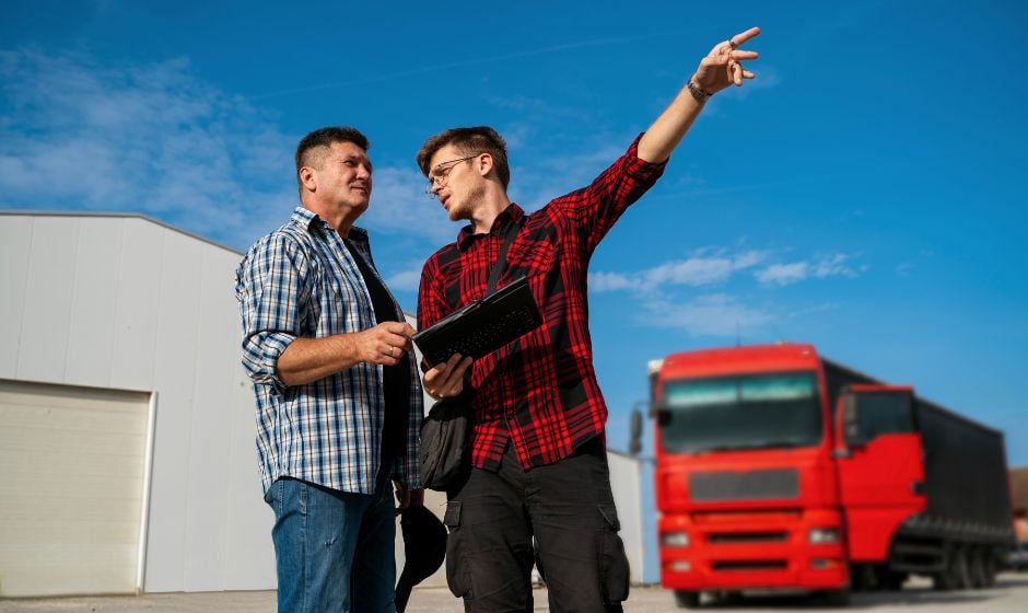 Trucker talking with manager in front of truck