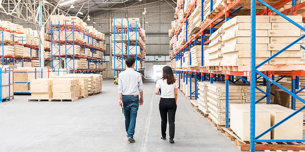 Two people walking through a warehouse