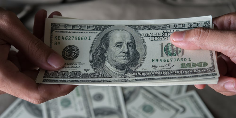 Closeup-handing-stack-of-100-dollar-bills