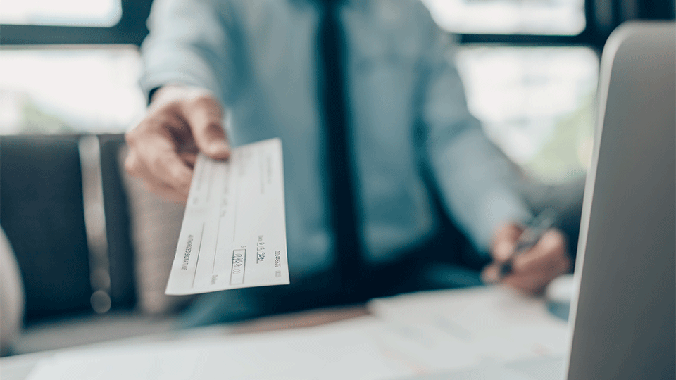 Man handing over paycheck to salesperson