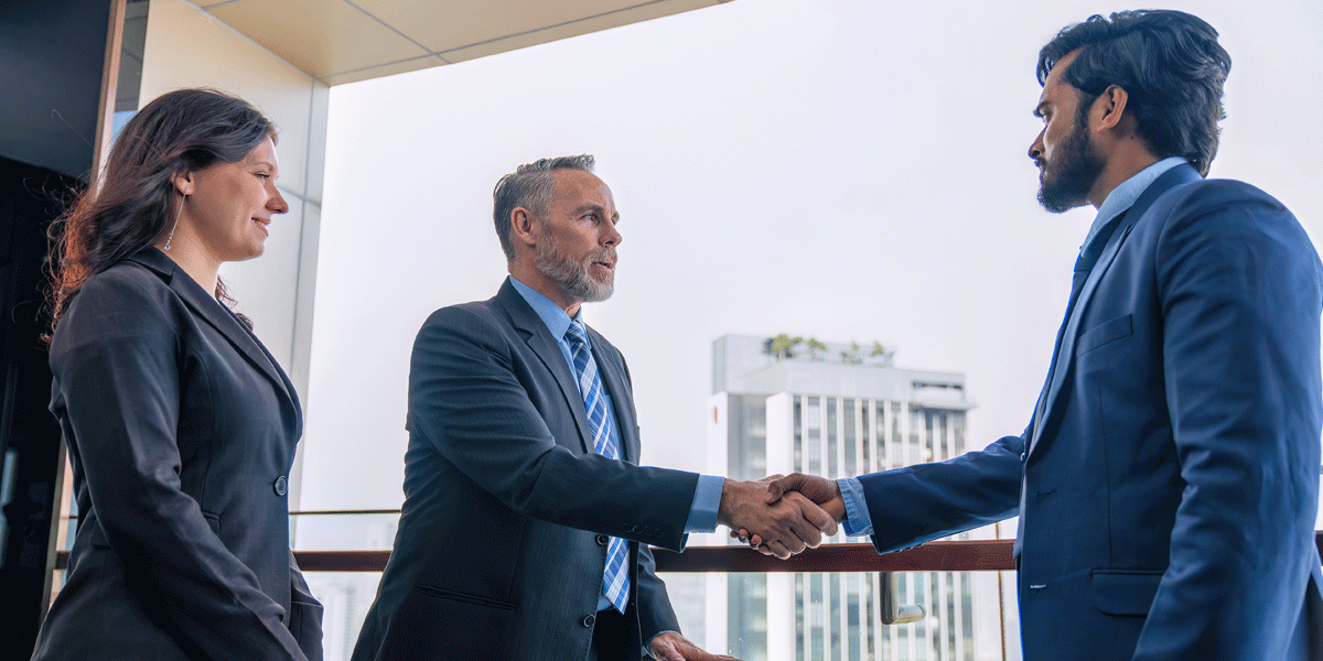 Chief executive officer with secretary meet up with business man and shake hands.