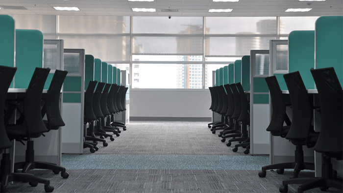 An empty brokerage office with rows of cubicles and office chairs