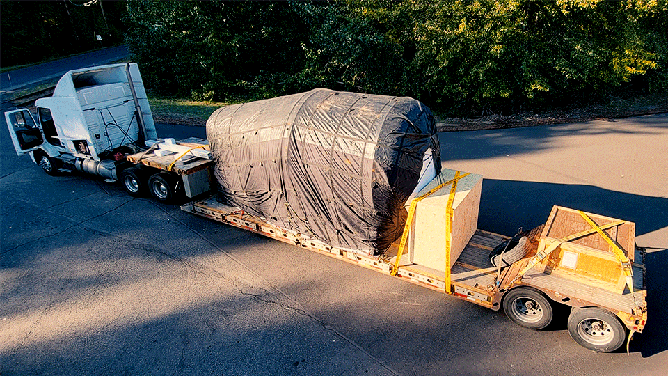 An oversized load travels on a double-drop open-deck trailer