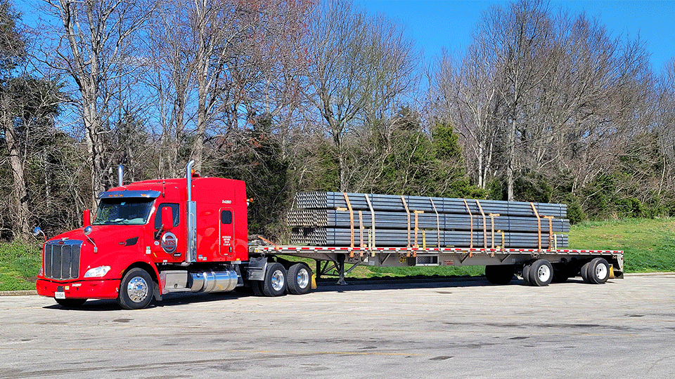 A multi-axle flatbed truck with a secured shipment