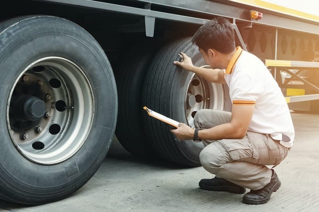 Inspector examining semi-truck tires