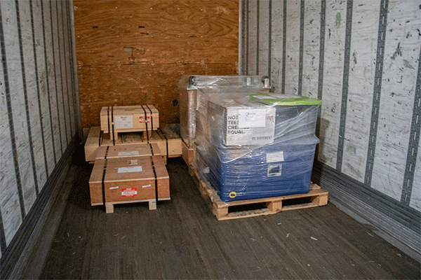Wood dunnage pallets and plastic wrap in use for a LTL shipment.