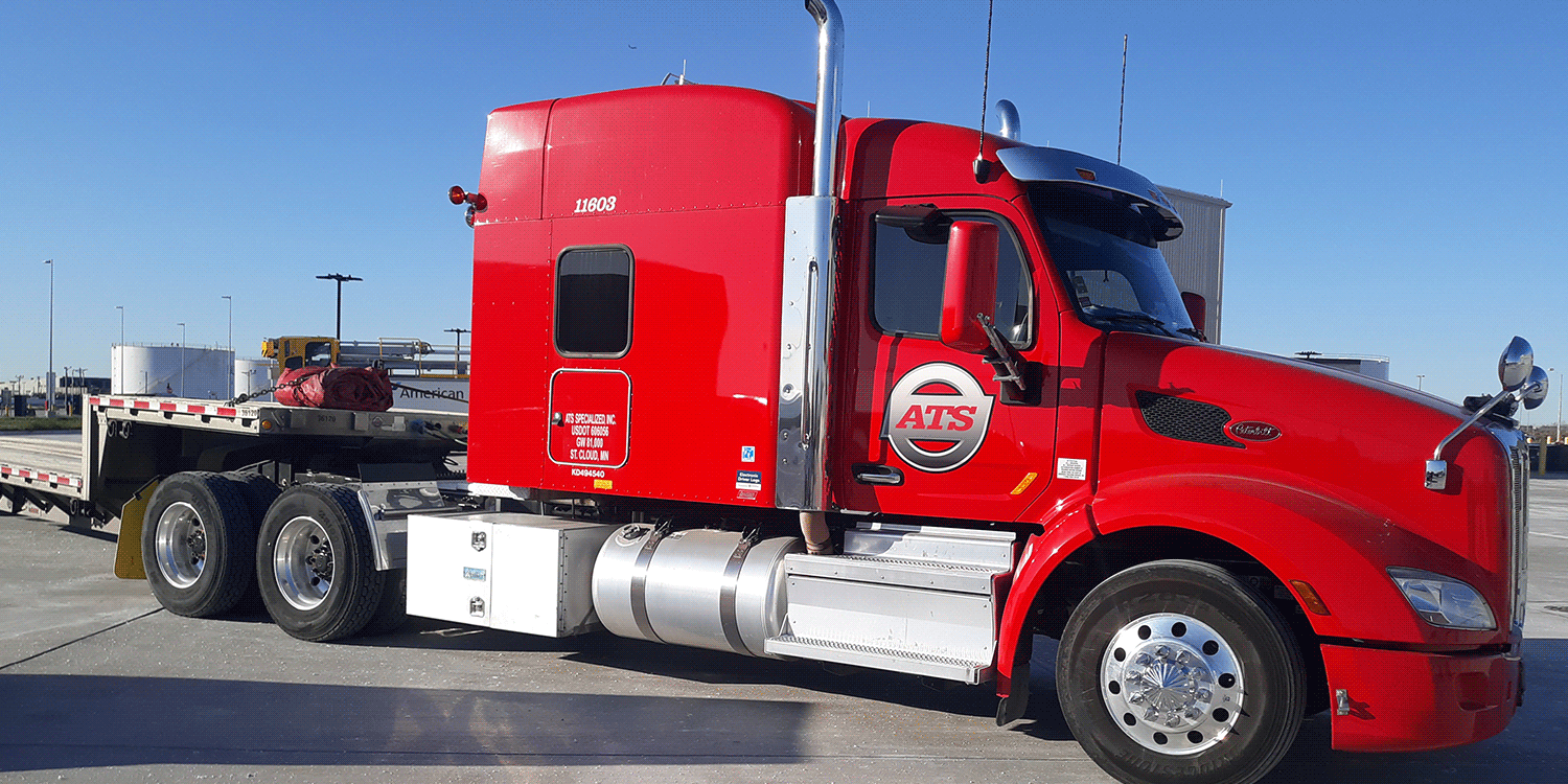 Closeup of red semi-truck and step-deck trailer