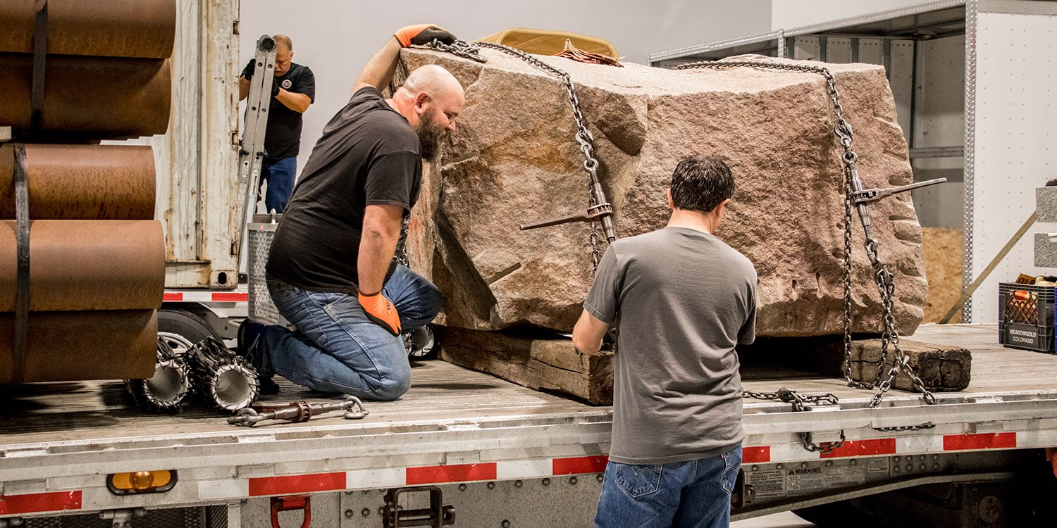Truck drivers practice securing a load on a flatbed trailer