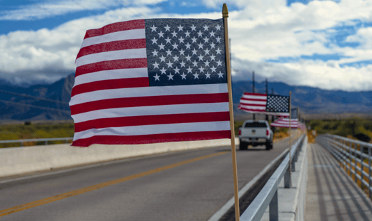 American flags positioned along roadway. Memorial Day 2026 Oversize Freight Restrictions