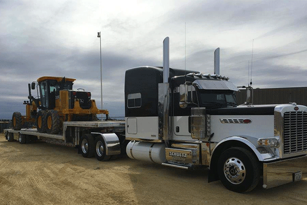 Drop deck trailer loaded with construction equipment