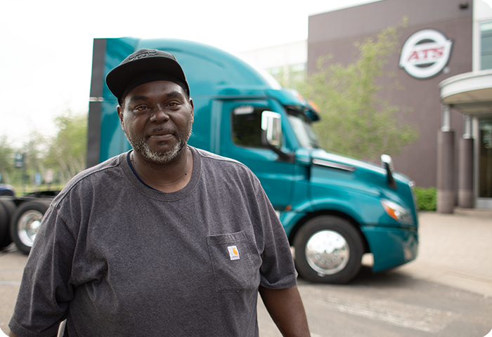 Truck driver with blue semi truck outside ATS Corporate HQ