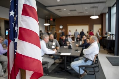 Veterans share story over breakfast with American flag in foreground