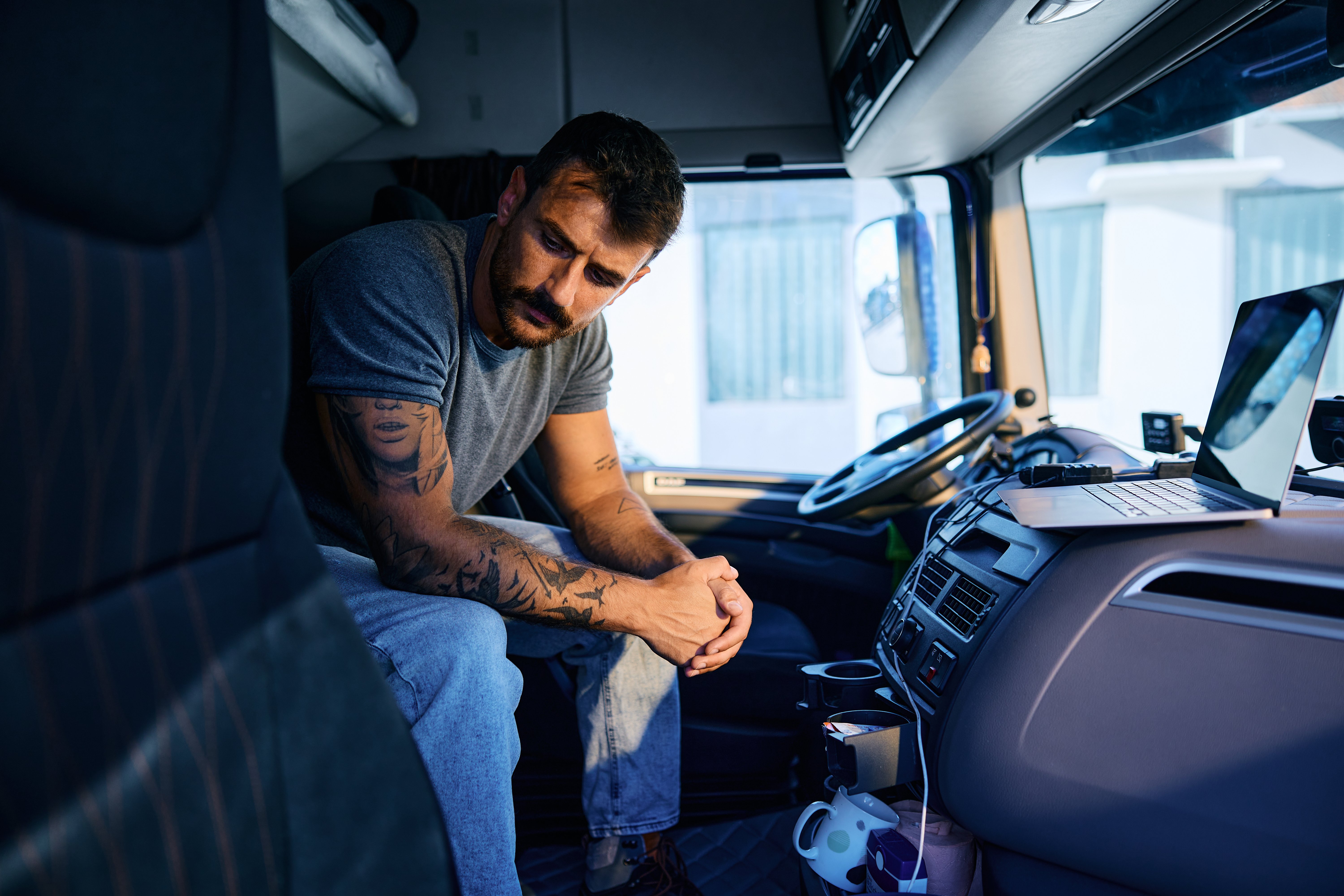Pensive truck driver sitting along in truck cab