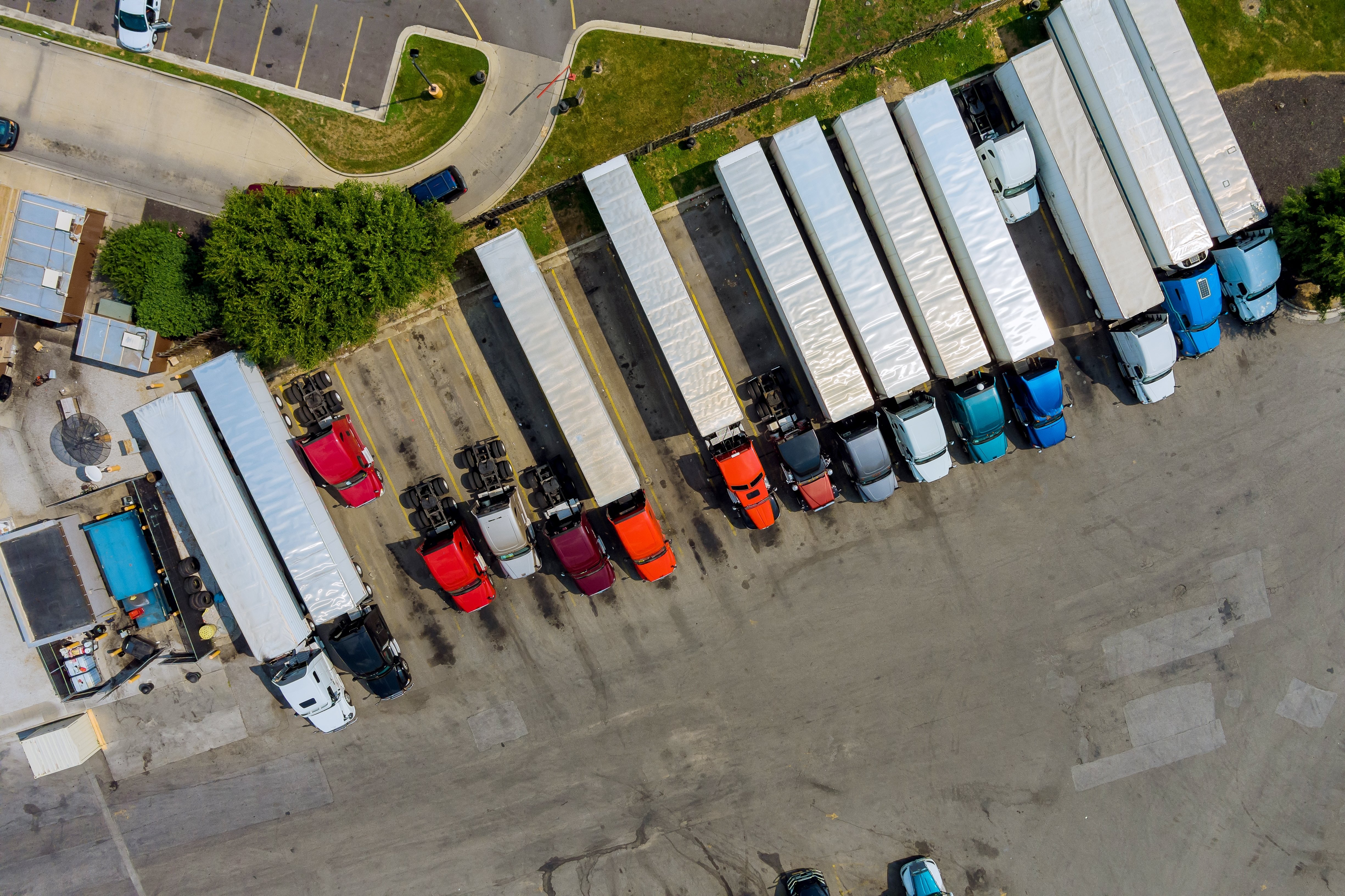 Overhead view of a truck yard full of parked semi trucks and trailers