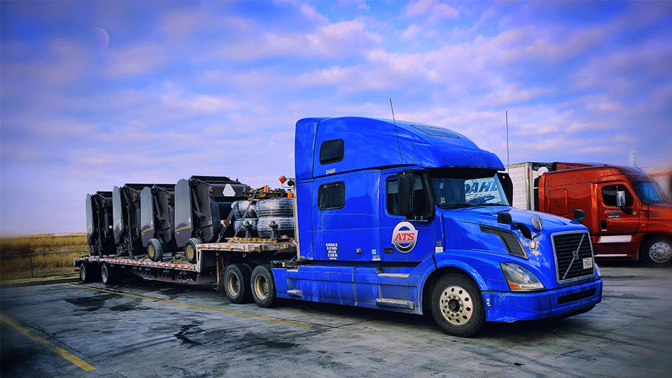 step deck semi trailer loaded with equipment