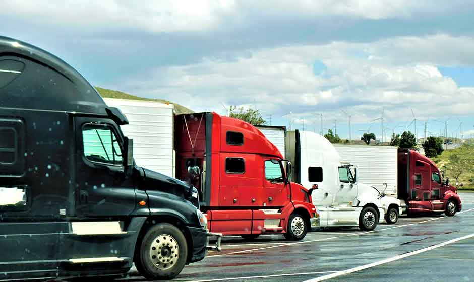 four semi trucks parked in lot