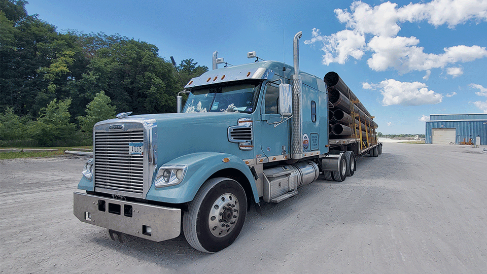 Flatbed-hauling-metal-piping