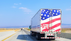 A semi truck with an American flag painted on the trailer doors
