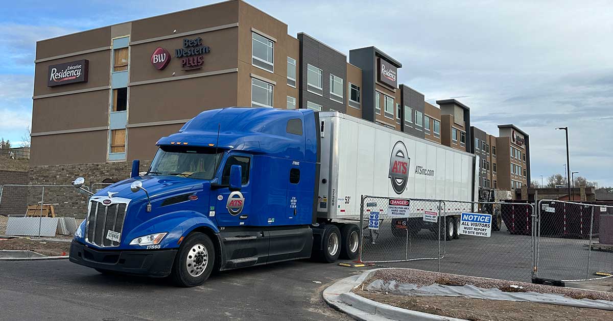 Blue-semi-truck-outside-hotel-unloading-cargo