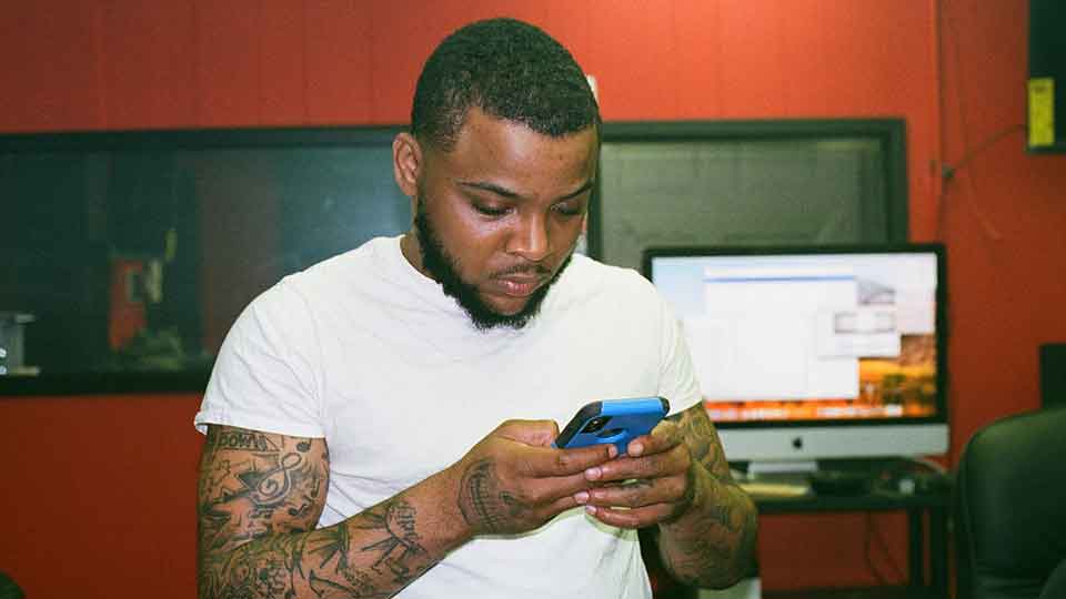 man sending an email on a cell phone