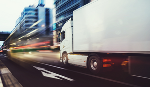 A dry van truck travels quickly through a metropolitan area