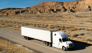 A dry van truck and trailer traveling in the desert